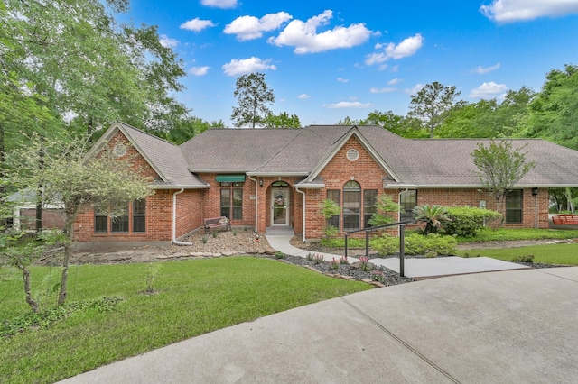 5 Highland Hollow Dr, Conroe, TX 77304 - single story home featuring brick siding, a front lawn, and a shingled roof
