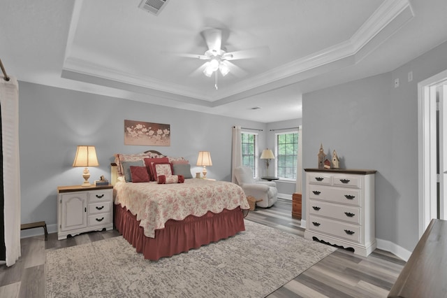 5 Highland Hollow Dr, Conroe, TX 77304 - bedroom featuring a raised ceiling, crown molding, wood finished floors, baseboards, and ceiling fan