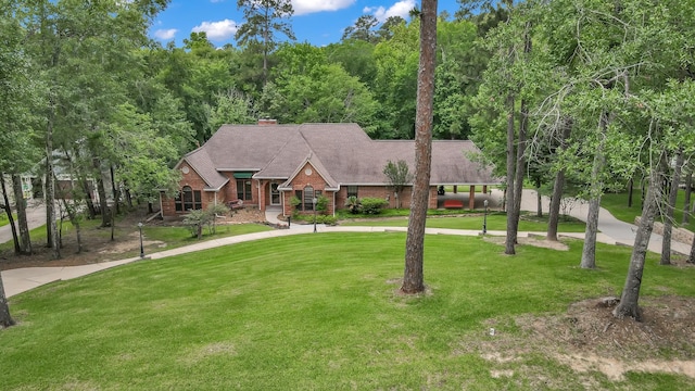 5 Highland Hollow Dr, Conroe, TX 77304 - view of front of home featuring a front yard, a chimney, and brick siding