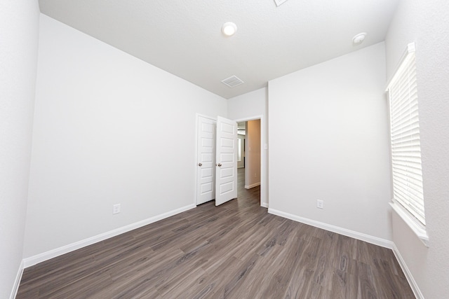 13609 Goldeye Dr, Conroe, TX 77384 - unfurnished bedroom featuring baseboards, visible vents, multiple windows, and wood finished floors