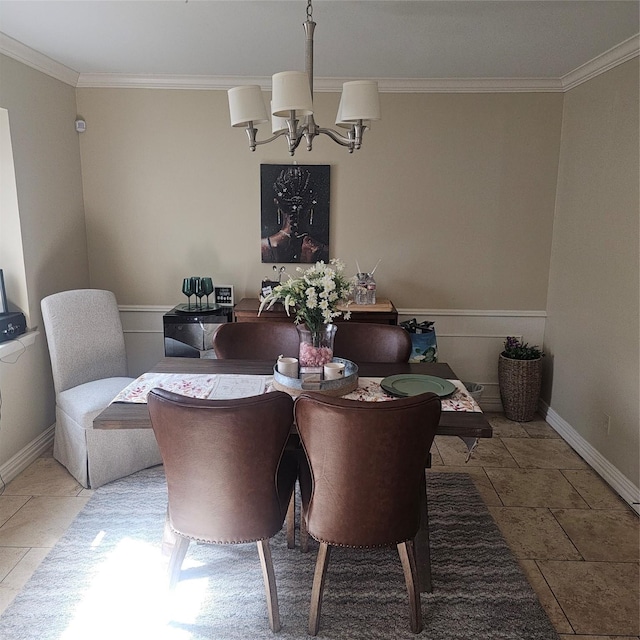 dining room with baseboards, ornamental molding, and a notable chandelier