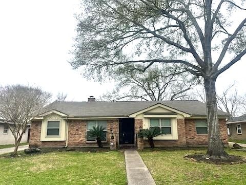 ranch-style house featuring a chimney and a front lawn