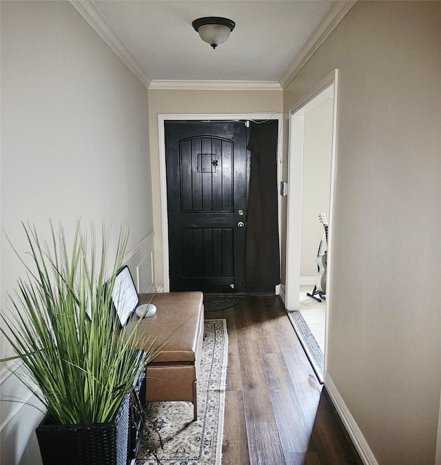 foyer with crown molding, baseboards, and wood finished floors