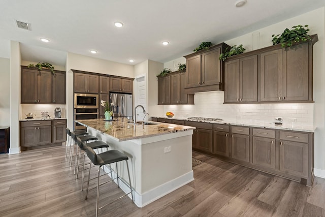 720 Serenity View Ln, Katy, TX 77493 - kitchen featuring stainless steel appliances, visible vents, a sink, and light wood-style floors