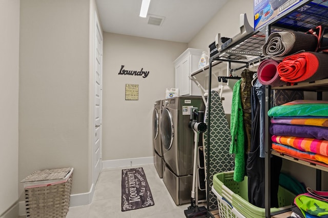 720 Serenity View Ln, Katy, TX 77493 - clothes washing area with visible vents, washing machine and clothes dryer, cabinet space, light tile patterned floors, and baseboards