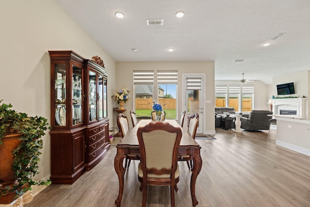 720 Serenity View Ln, Katy, TX 77493 - dining room featuring a fireplace, baseboards, recessed lighting, a ceiling fan, and light wood finished floors