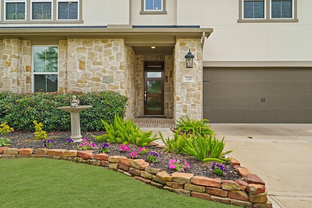 720 Serenity View Ln, Katy, TX 77493 - view of exterior entry featuring a garage, stucco siding, stone siding, and concrete driveway