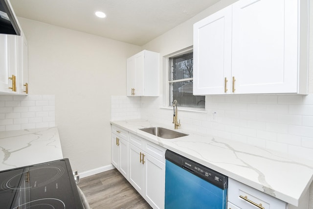 kitchen with dishwashing machine, extractor fan, white cabinets, a sink, and light wood-style flooring