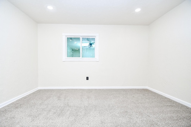 empty room with baseboards, recessed lighting, and carpet