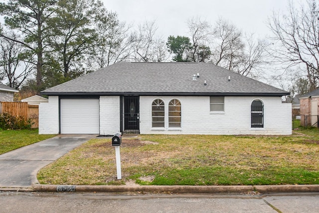 ranch-style home featuring fence, a front yard, driveway, and roof with shingles