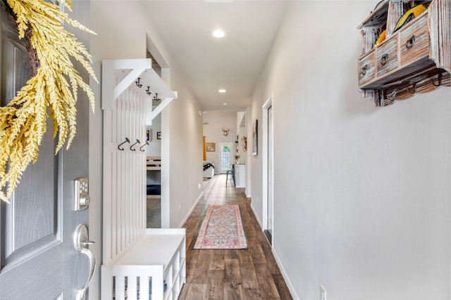 hallway featuring wood finished floors, recessed lighting, and baseboards