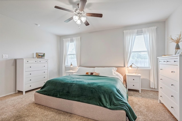 carpeted bedroom with ceiling fan and baseboards
