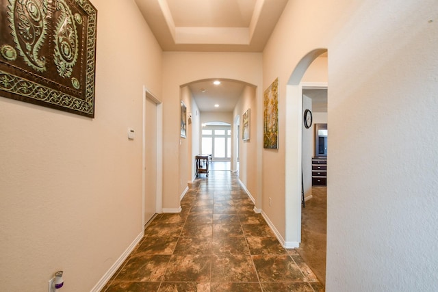 hall with arched walkways and baseboards