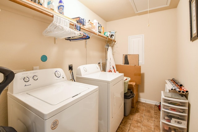 washroom featuring washing machine and clothes dryer, laundry area, baseboards, and attic access