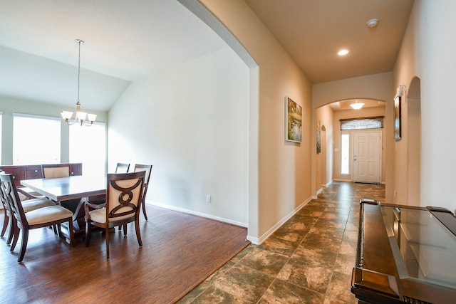 dining area with an inviting chandelier, baseboards, recessed lighting, arched walkways, and vaulted ceiling