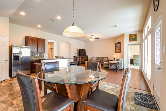 dining area with visible vents, ceiling fan, stone finish floor, recessed lighting, and arched walkways