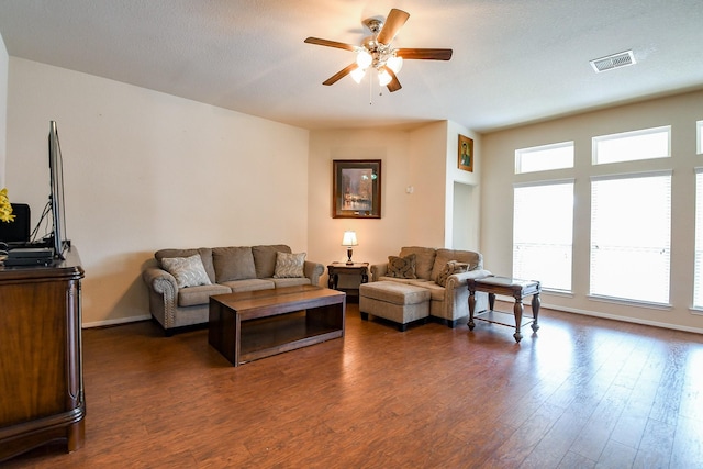 living room with ceiling fan, dark wood finished floors, baseboards, and visible vents