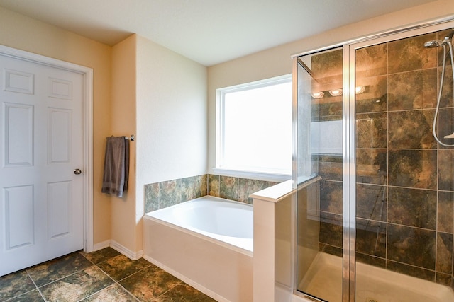 full bath featuring baseboards, a stall shower, and a garden tub