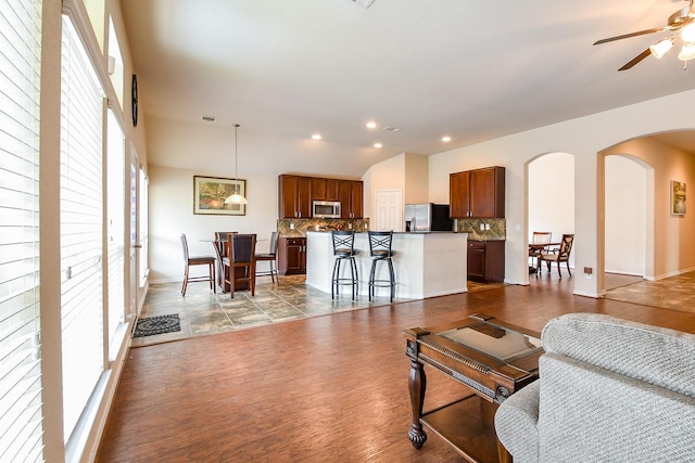 living room with plenty of natural light, arched walkways, a ceiling fan, and recessed lighting