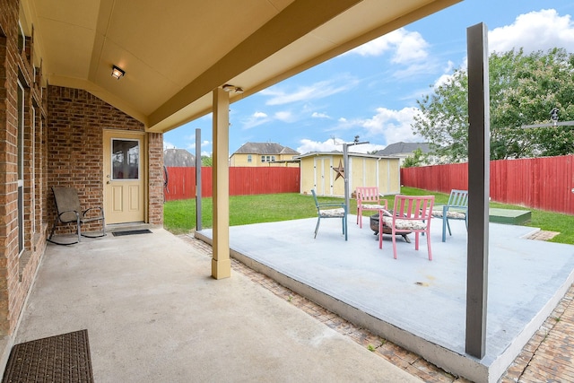 view of patio featuring a fenced backyard, an outbuilding, and a shed