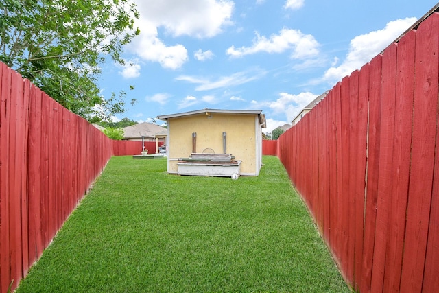 back of house featuring a fenced backyard, stucco siding, and a yard