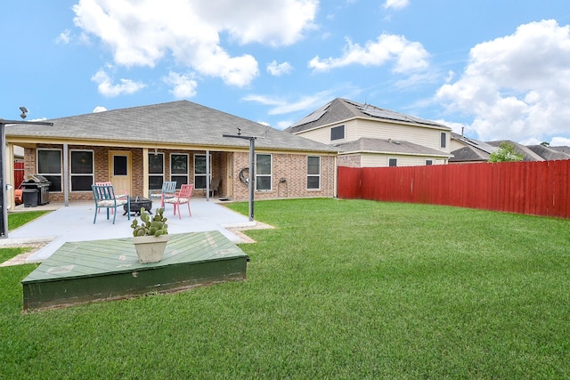 back of property featuring a lawn, a patio, a fire pit, and a fenced backyard