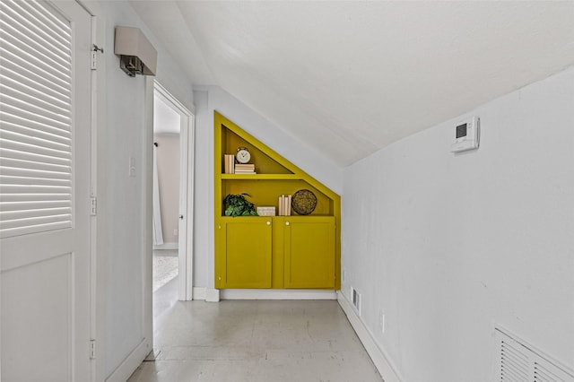 corridor with visible vents and vaulted ceiling