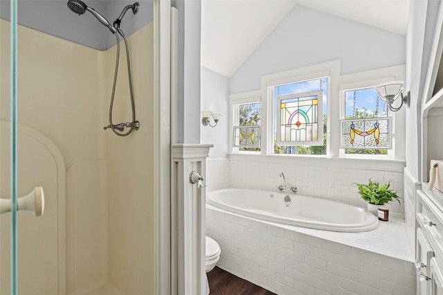 bathroom with toilet, a shower stall, wood finished floors, lofted ceiling, and a garden tub