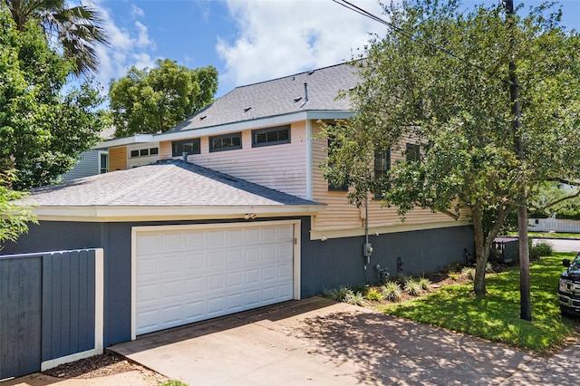 view of front of house with a garage, a shingled roof, and concrete driveway