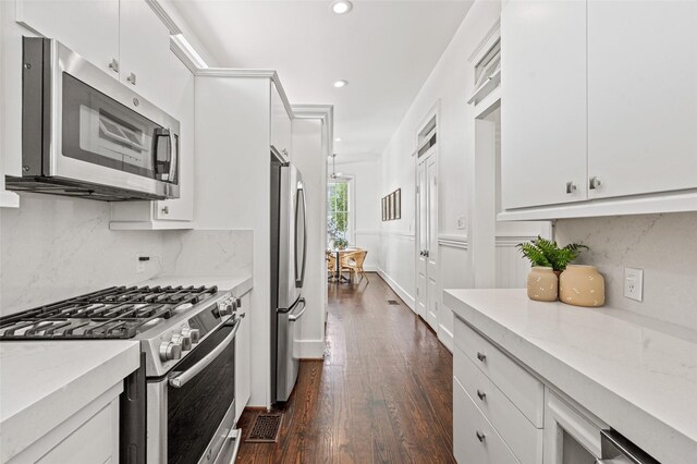 kitchen with white cabinets, appliances with stainless steel finishes, dark wood finished floors, recessed lighting, and decorative backsplash