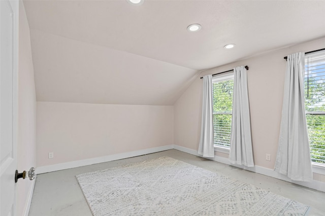 additional living space featuring recessed lighting, baseboards, vaulted ceiling, and a wealth of natural light