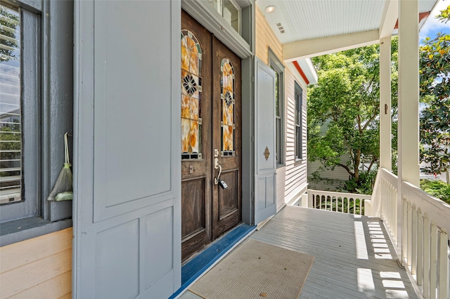 view of exterior entry featuring covered porch