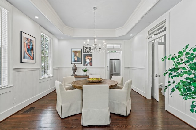 dining space featuring wainscoting, a chandelier, a tray ceiling, visible vents, and dark wood-style floors