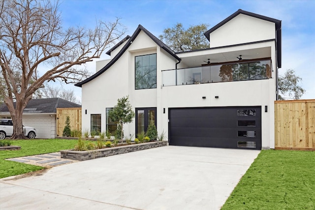 contemporary home featuring a garage, a front lawn, fence, stucco siding, and concrete driveway