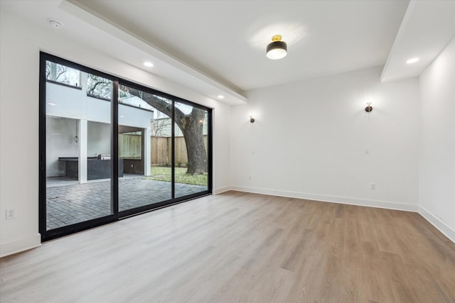spare room with baseboards, recessed lighting, and wood finished floors
