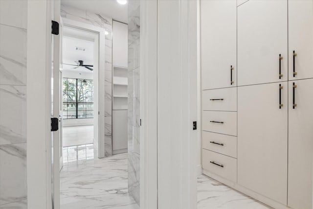 spacious closet with visible vents, a ceiling fan, and marble finish floor
