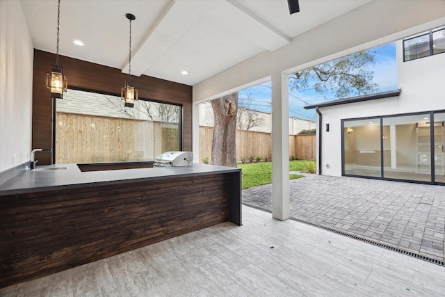 interior space featuring recessed lighting, a sink, pendant lighting, and wooden walls