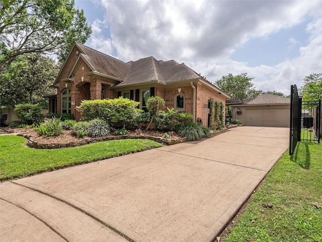 view of front facade featuring brick siding, fence, a front lawn, and a garage