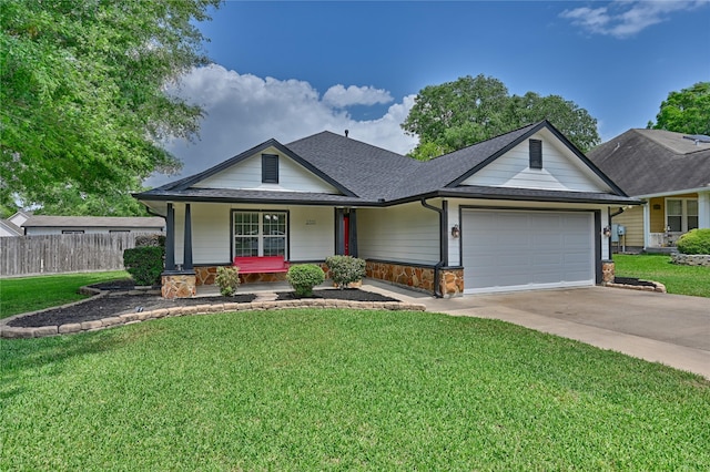 view of front of house featuring covered porch, roof with shingles, fence, an attached garage, and stone siding