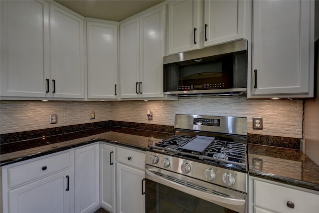 kitchen with white cabinets, stainless steel appliances, dark stone countertops, and tasteful backsplash