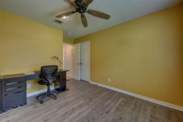 office area featuring visible vents, a ceiling fan, baseboards, and wood finished floors