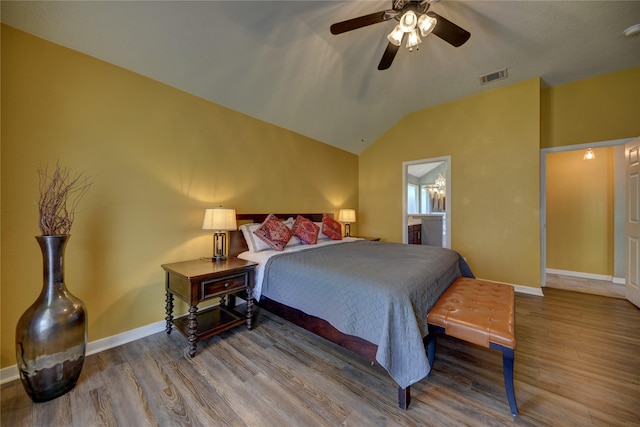 bedroom with baseboards, visible vents, wood finished floors, and lofted ceiling