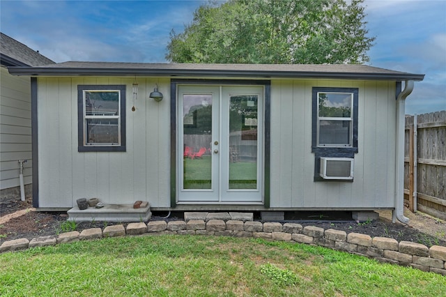 view of outbuilding with an outdoor structure, fence, and french doors