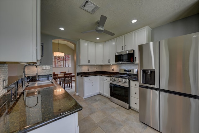 kitchen with visible vents, a ceiling fan, backsplash, and stainless steel appliances