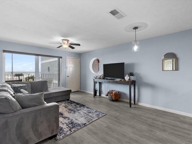7600 Seawall Blvd Unit 113, Galveston, TX 77551 - living area with visible vents, a ceiling fan, baseboards, and wood finished floors