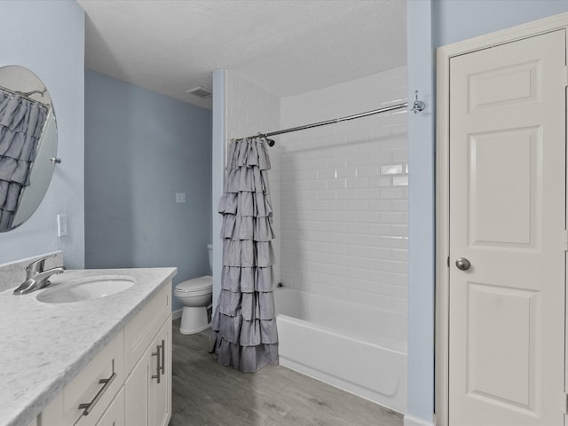 7600 Seawall Blvd Unit 113, Galveston, TX 77551 - bathroom featuring vanity, toilet, shower / bathtub combination with curtain, wood finished floors, and visible vents