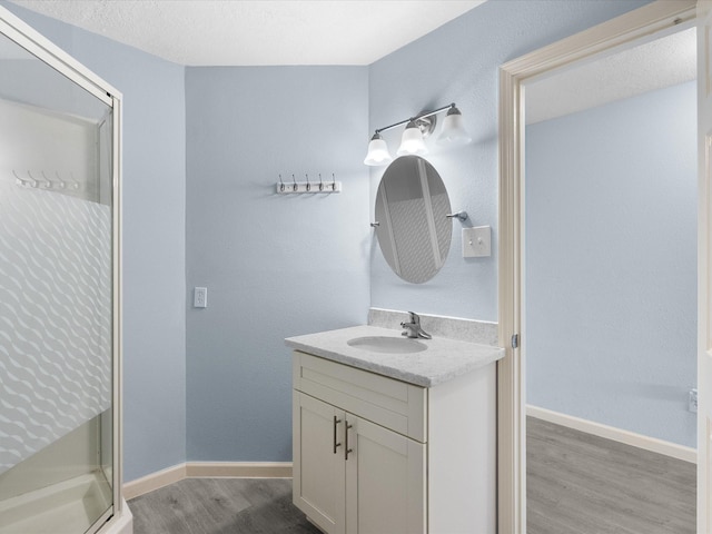 7600 Seawall Blvd Unit 113, Galveston, TX 77551 - full bath with vanity, baseboards, wood finished floors, and a stall shower