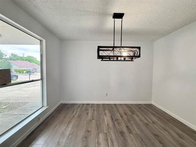 6410 Rancho Blanco Ct, Houston, TX 77083 - unfurnished dining area with wood finished floors, a chandelier, a textured ceiling, and baseboards