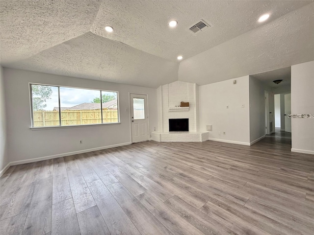 6410 Rancho Blanco Ct, Houston, TX 77083 - unfurnished living room with a textured ceiling, wood finished floors, plenty of natural light, baseboards, and lofted ceiling