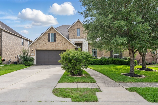 3422 Leaning Willow Dr, Katy, TX 77494 - view of front of house with stone siding, a garage, brick siding, a front yard, and concrete driveway